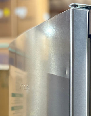 Open box Miele KFN12823SD 24-inch bottom freezer refrigerator in stainless steel – front view small dent on top door
