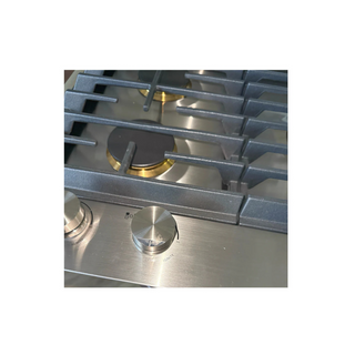 Stainless steel gas stove with grates and burners on a white background, scratch on knob